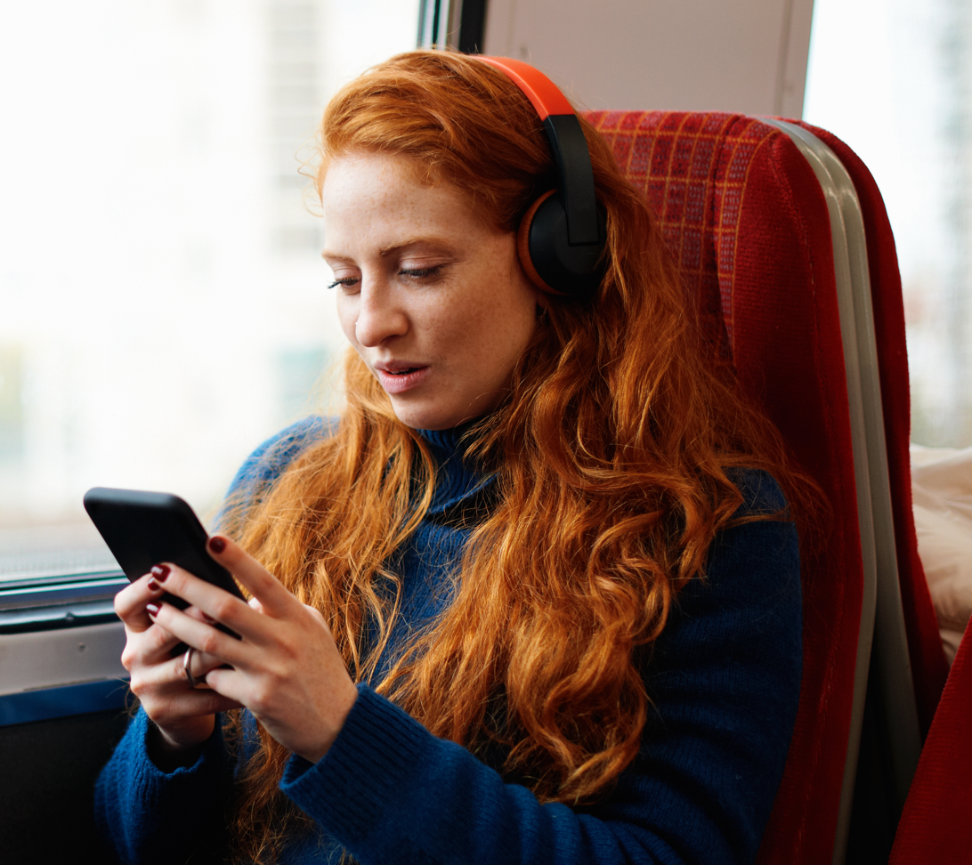 Woman on train looking at employee financial advice on mobile phone