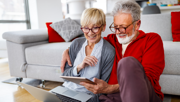 A retired couple previews Vanguard’s 2024 financial and fiduciary well-being calendar on a handheld device. 